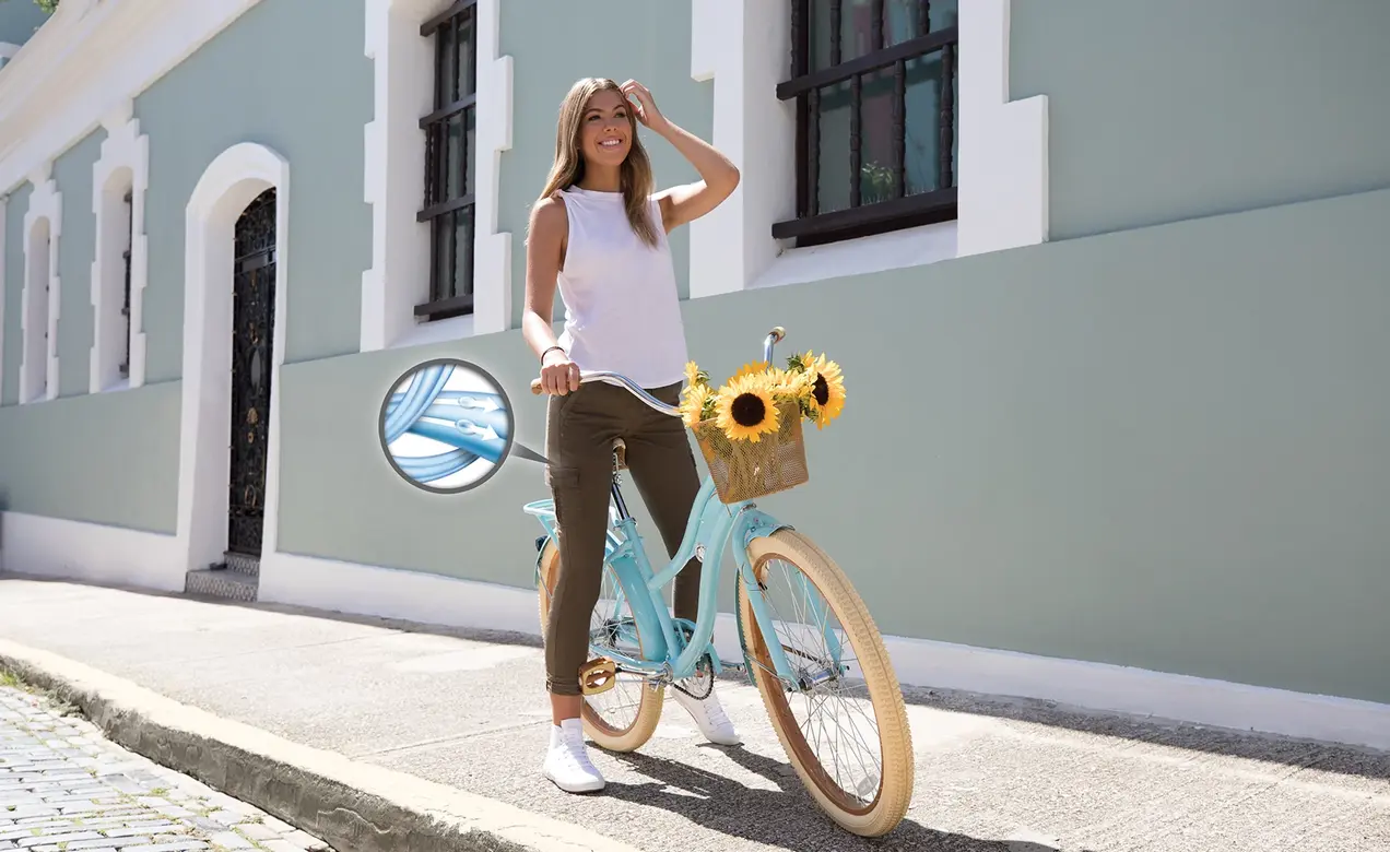 Woman riding a bicycle wearing garments made with COOLMAX® EcoMade technology